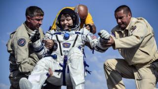 أشخاص يساعدون رائدة الفضاء، آن مكلين، لدى عودتها من محطة الفضاء الدولية في يونيو/ حزيران الماضي.